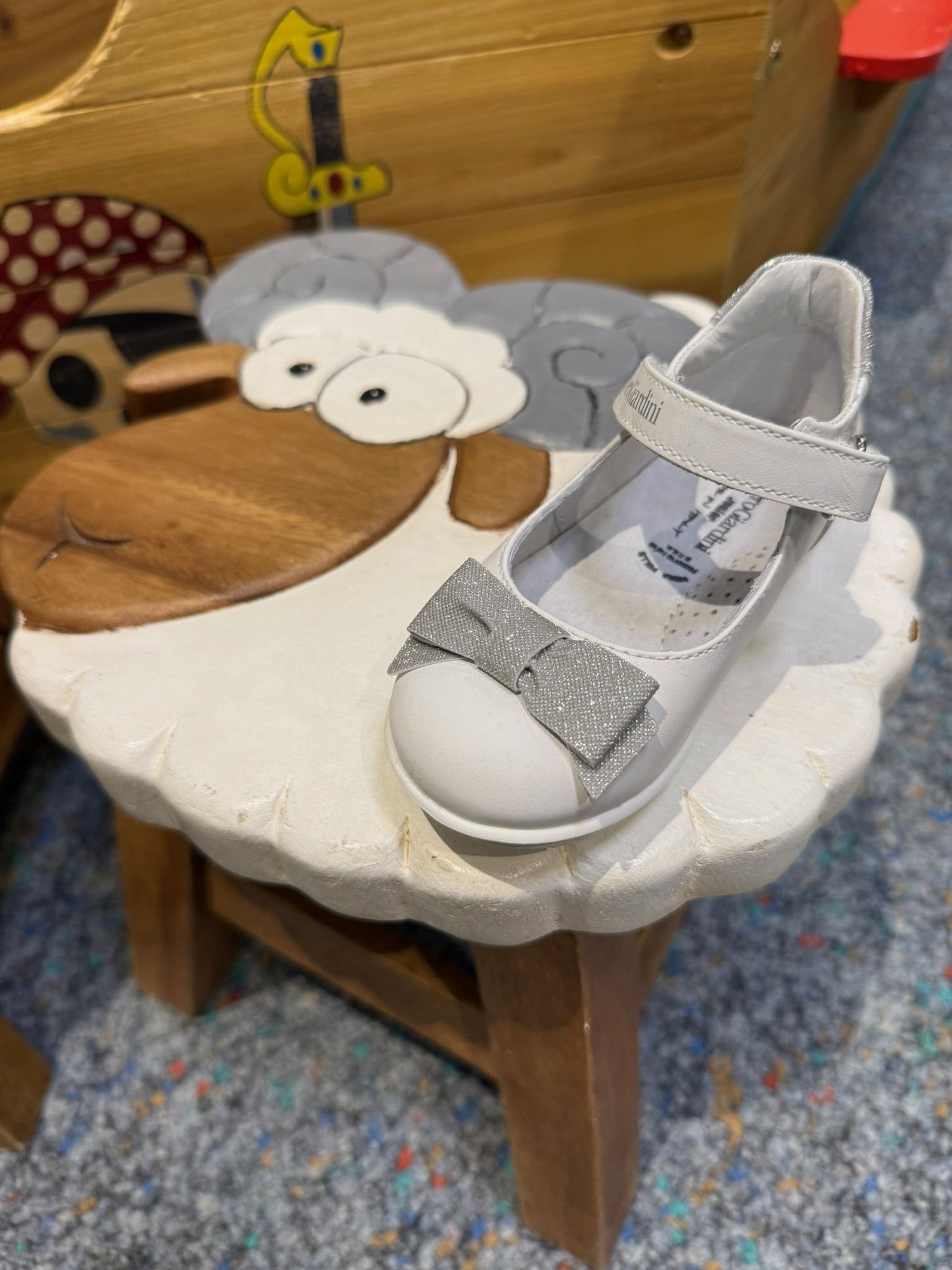 Kinderschuh auf einem Schaf-Hocker bei Shoez